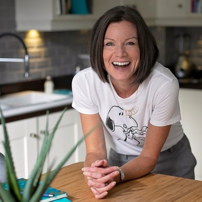 Sarah smiling and leaning on table